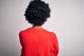 Young beautiful African American afro woman with curly hair wearing red casual sweater standing backwards looking away with Royalty Free Stock Photo