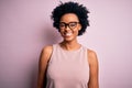 Young beautiful African American afro woman with curly hair wearing t-shirt and glasses with a happy and cool smile on face Royalty Free Stock Photo