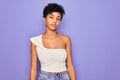 Young beautiful african american afro woman wearing casual t-shirt over purple background looking sleepy and tired, exhausted for