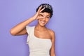 Young beautiful african american afro woman wearing tiara crown over purple background doing ok gesture with hand smiling, eye Royalty Free Stock Photo