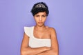 Young beautiful african american afro woman wearing tiara crown over purple background skeptic and nervous, disapproving Royalty Free Stock Photo