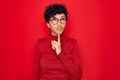 Young beautiful african american afro woman wearing turtleneck sweater and glasses Thinking concentrated about doubt with finger Royalty Free Stock Photo