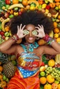 African American woman smiles closing her eyes with kiwi Royalty Free Stock Photo