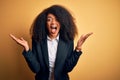 Young beautiful african american business woman with afro hair wearing elegant jacket celebrating crazy and amazed for success Royalty Free Stock Photo