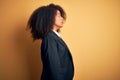 Young beautiful african american business woman with afro hair wearing elegant jacket looking to side, relax profile pose with Royalty Free Stock Photo