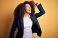 Young beautiful african american business woman with afro hair wearing elegant jacket very happy and smiling looking far away with Royalty Free Stock Photo