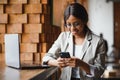 Young beautiful African-American business woman talking on the phone while working in a cafe Royalty Free Stock Photo