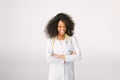 Young beautiful African American girl doctor in a white coat with a stethoscope. on white background