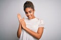 Young beautiful african american girl wearing casual t-shirt standing over white background clapping and applauding happy and Royalty Free Stock Photo