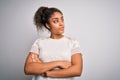 Young beautiful african american girl wearing casual t-shirt standing over white background looking to the side with arms crossed Royalty Free Stock Photo