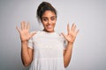 Young beautiful african american girl wearing casual t-shirt standing over white background showing and pointing up with fingers Royalty Free Stock Photo