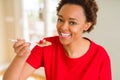 Young beautiful african american woman with afro hair eating healthy wholemeal cereals and berries as healthy breakfast