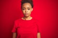 Young beautiful african american woman with afro hair over isolated red background Relaxed with serious expression on face Royalty Free Stock Photo