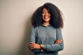 Young beautiful african american woman with afro hair standing over isolated background happy face smiling with crossed arms Royalty Free Stock Photo