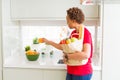 Young beautiful african american woman holding paper bag full of fresh healthy groceries and picking vegetables Royalty Free Stock Photo