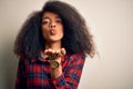 Young beautiful african american woman wearing casual shirt over isolated background looking at the camera blowing a kiss with Royalty Free Stock Photo