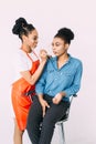 Young beautiful African American woman applying professional make-up by African make-up artist. Studio shoot Royalty Free Stock Photo