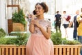 Young beautiful African girl talking on cell phone outdoors in pink dress Royalty Free Stock Photo