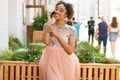 Young beautiful African girl talking on cell phone outdoors in pink dress Royalty Free Stock Photo