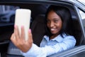 Young beautiful African Zulu businesswoman riding inside the car