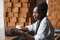 Young beautiful Afro-American businesswoman using laptop while working in cafe Royalty Free Stock Photo