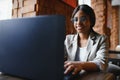 Young beautiful Afro-American businesswoman using laptop while working in cafe Royalty Free Stock Photo