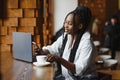 Young beautiful Afro-American businesswoman using laptop while working in cafe Royalty Free Stock Photo