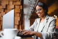 Young beautiful Afro-American businesswoman using laptop while working in cafe Royalty Free Stock Photo