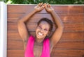 Young and beautiful Afro American woman doing different postures and expressions on a wooden background. The woman is smiling, sad Royalty Free Stock Photo