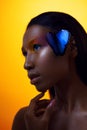 Young beautiful afro girl, with blue butterfly, beauty portrait on yellow background Royalty Free Stock Photo