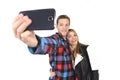 Young beautiful American couple in love taking romantic self portrait selfie photo together with mobile phone Royalty Free Stock Photo