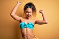 Young beautiful american woman on vacation wearing bikini over isolated yellow background Dancing happy and cheerful, smiling Royalty Free Stock Photo