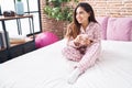 Young beautiful arab woman drinking cup of coffee sitting on bed at bedroom Royalty Free Stock Photo