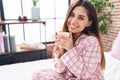 Young beautiful arab woman drinking cup of coffee sitting on bed at bedroom Royalty Free Stock Photo