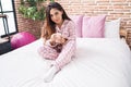 Young beautiful arab woman drinking cup of coffee sitting on bed at bedroom Royalty Free Stock Photo