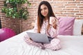 Young beautiful arab woman using laptop drinking coffee at bedroom Royalty Free Stock Photo