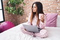 Young beautiful arab woman using laptop drinking coffee at bedroom Royalty Free Stock Photo