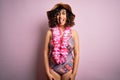 Young beautiful arab woman on vacation wearing swimsuit and hawaiian lei flowers sticking tongue out happy with funny expression Royalty Free Stock Photo