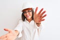 Young beautiful architect woman wearing helmet and glasses over isolated white background looking at the camera smiling with open Royalty Free Stock Photo