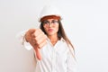 Young beautiful architect woman wearing helmet and glasses over isolated white background looking unhappy and angry showing Royalty Free Stock Photo