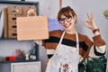 Young beautiful artist woman holding wooden case doing ok sign with fingers, smiling friendly gesturing excellent symbol Royalty Free Stock Photo