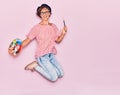 Young beautiful artist woman wearing glasses and beret smiling happy