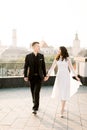 Young beautiful Asian bride and groom on the wedding day walking and dancing on the rooftop of old city. Ancient city Royalty Free Stock Photo