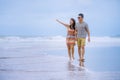 young beautiful Asian Chinese couple walkingyoung beautiful Asian Chinese couple walking together holding hands on the beach Royalty Free Stock Photo