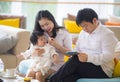 Young beautiful Asian Chinese family sitting at modern resort with workaholic man working business online with digital tablet and