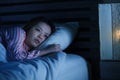 Young beautiful Asian Chinese girl lying on bed late night awake looking thoughtful suffering insomnia sleeping disorder feeling Royalty Free Stock Photo