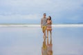 young beautiful and Asian Chinese romantic couple walking together embracing on the beach happy in love enjoying holidays Royalty Free Stock Photo