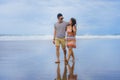 young beautiful and Asian Chinese romantic couple walking together embracing on the beach happy in love enjoying holidays Royalty Free Stock Photo