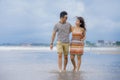 young beautiful and Asian Chinese romantic couple walking together embracing on the beach happy in love enjoying holidays Royalty Free Stock Photo