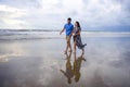 young beautiful and Asian Chinese romantic couple walking together holding hands on the beach happy in love enjoying holidays Royalty Free Stock Photo